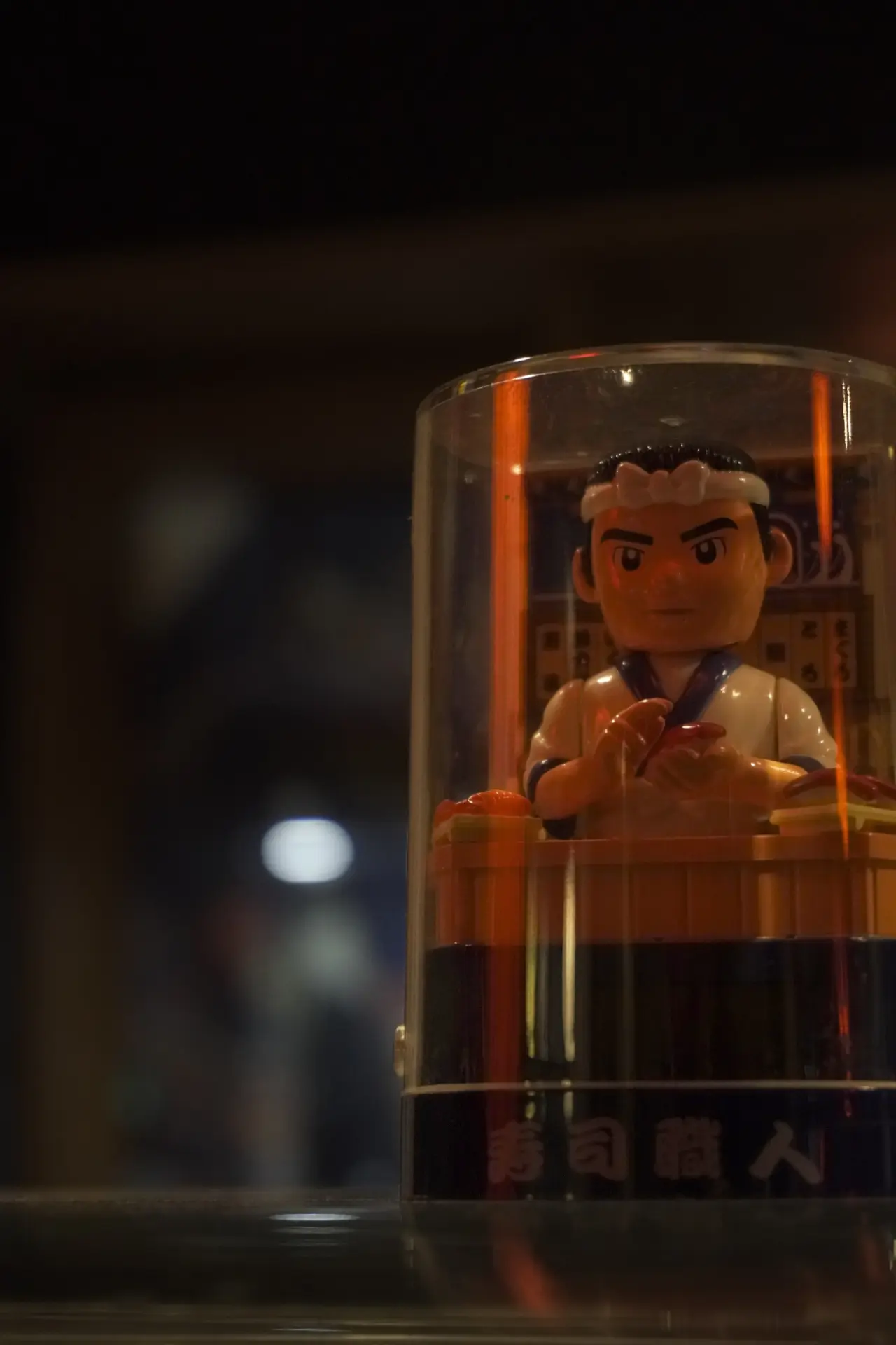 Figura de sushiman tradicional iluminada en la barra