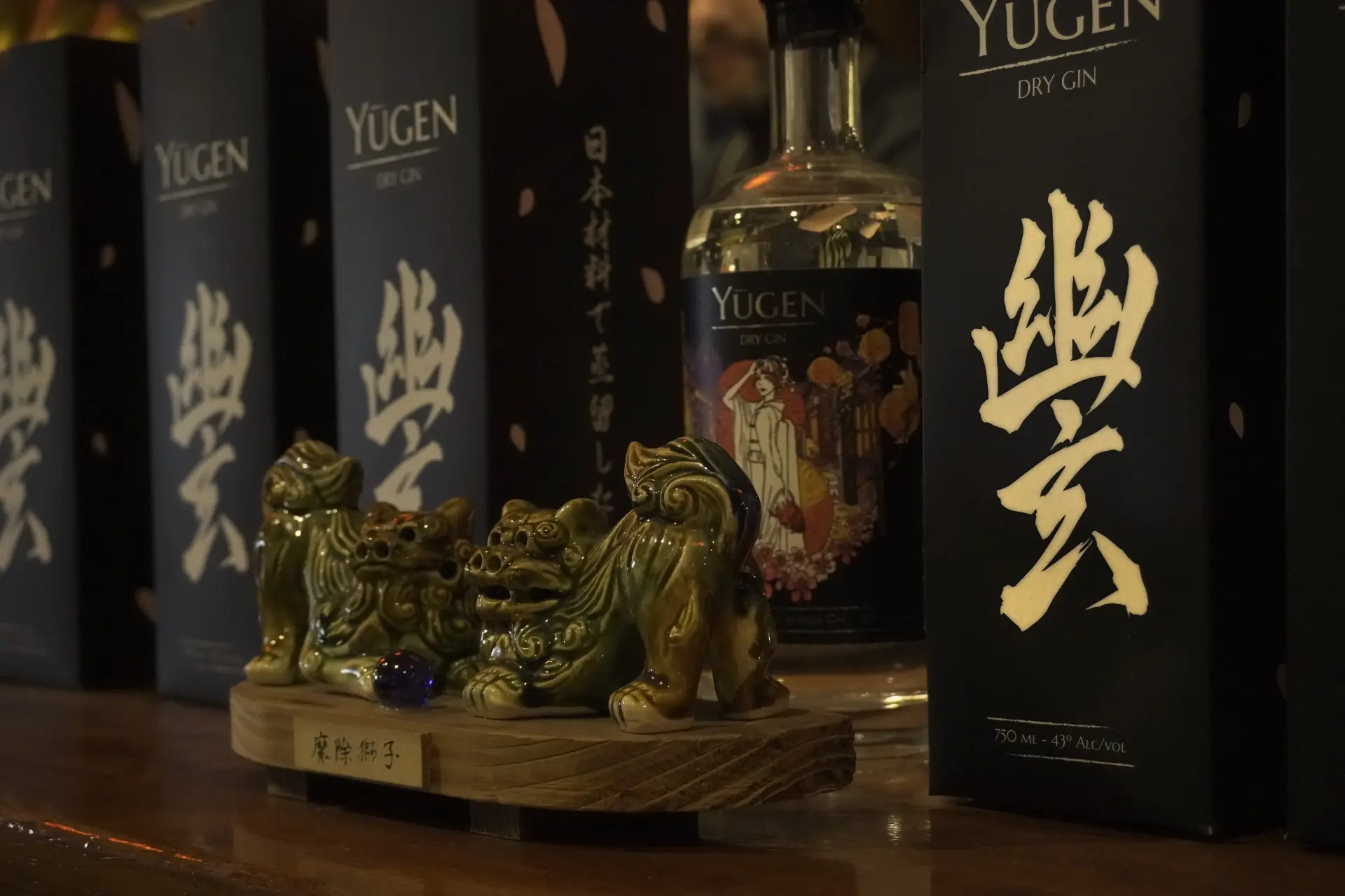 Shisas de cerámica junto a una botella de gin japonés Yūgen